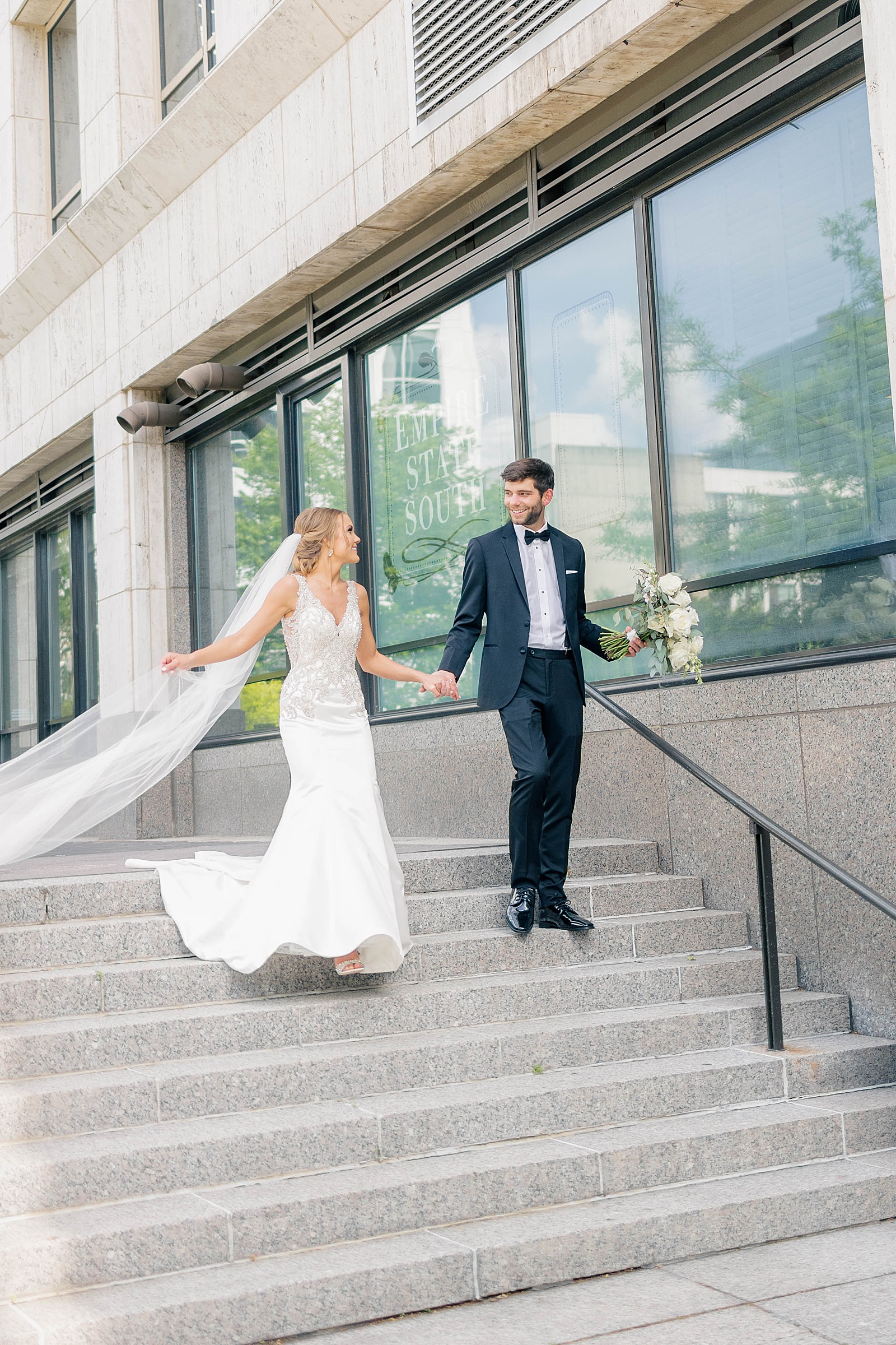 bride and groom walking down steps holding hands