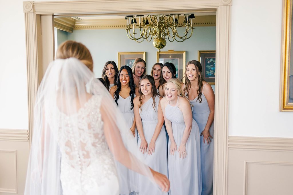 bride in wedding gown from Atlanta GA wedding dress shop showing bridesmaids her final wedding look for the first time
