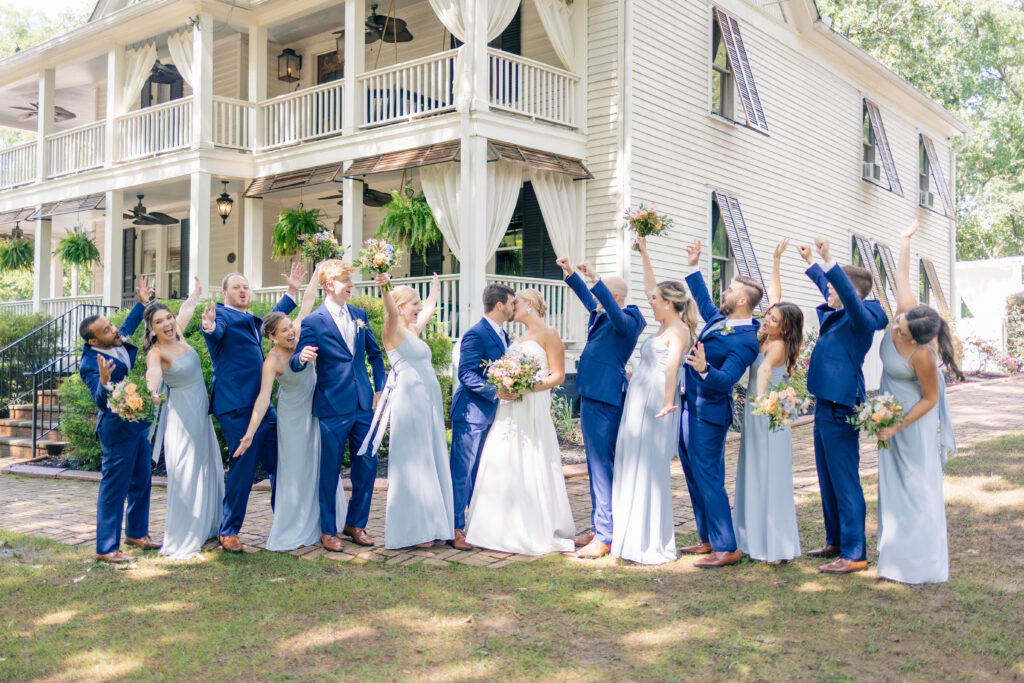 wedding party cheers to the bride and groom in front of The Wheeler House wedding venue
