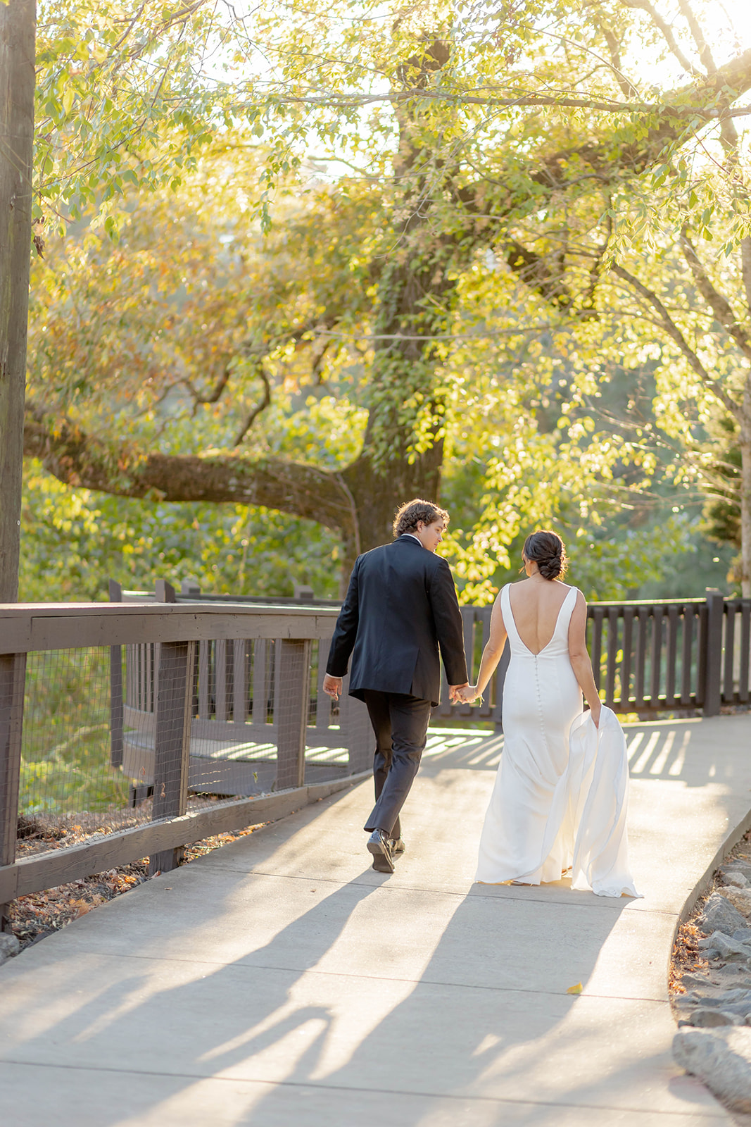 Newlyweds hold hands while exploring the walkways of the Ivy Hall Wedding Venue