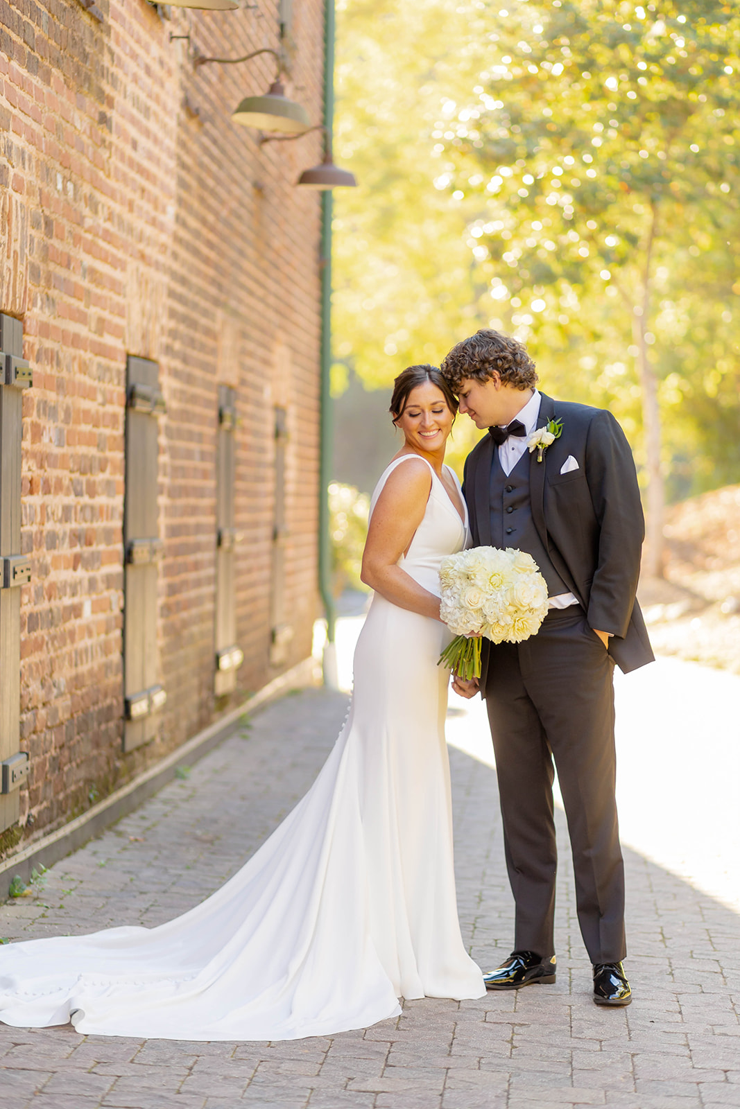 Newlyweds snuggle while standing behind the Ivy Hall Wedding Venue