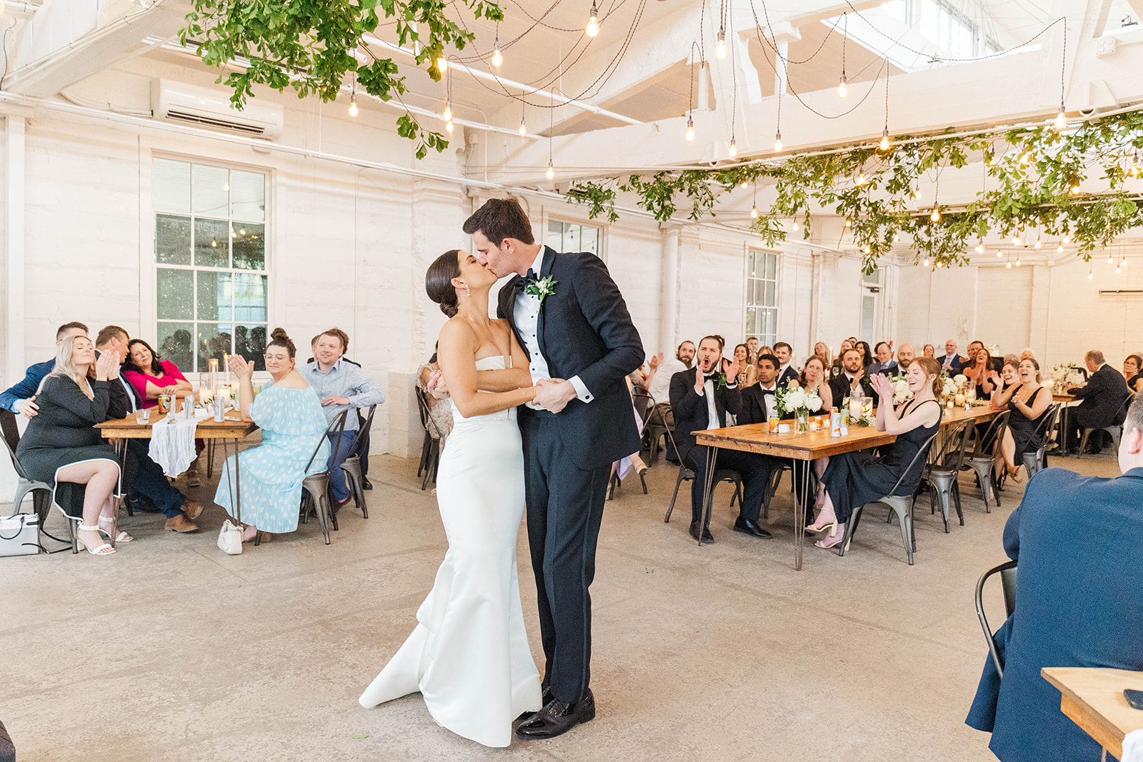 Newlyweds kiss while dancing on the dance floor to applaus from guests at their Upstairs Atlanta Wedding