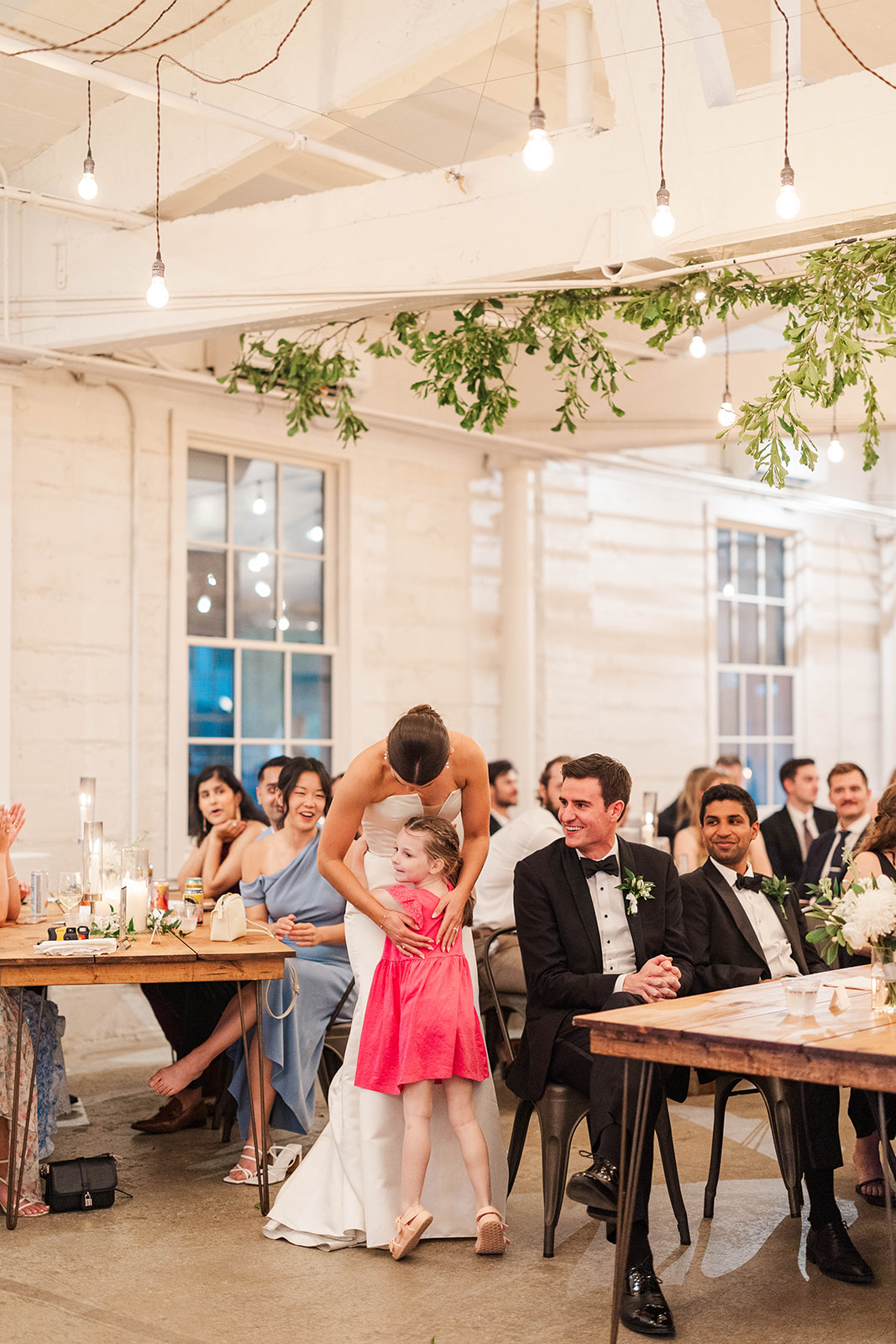 A young girl in a pink dress hugs the bride during her Upstairs Atlanta Wedding reception