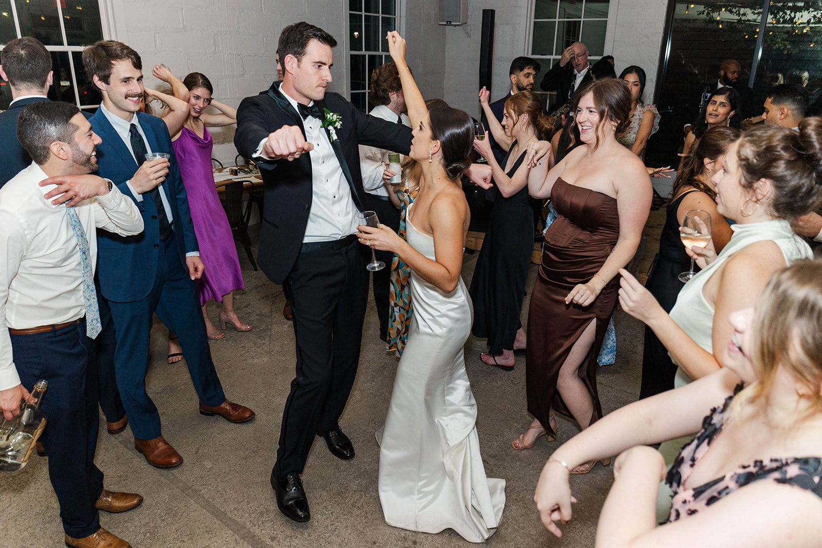 NEwlyweds dance with their guests on the patio