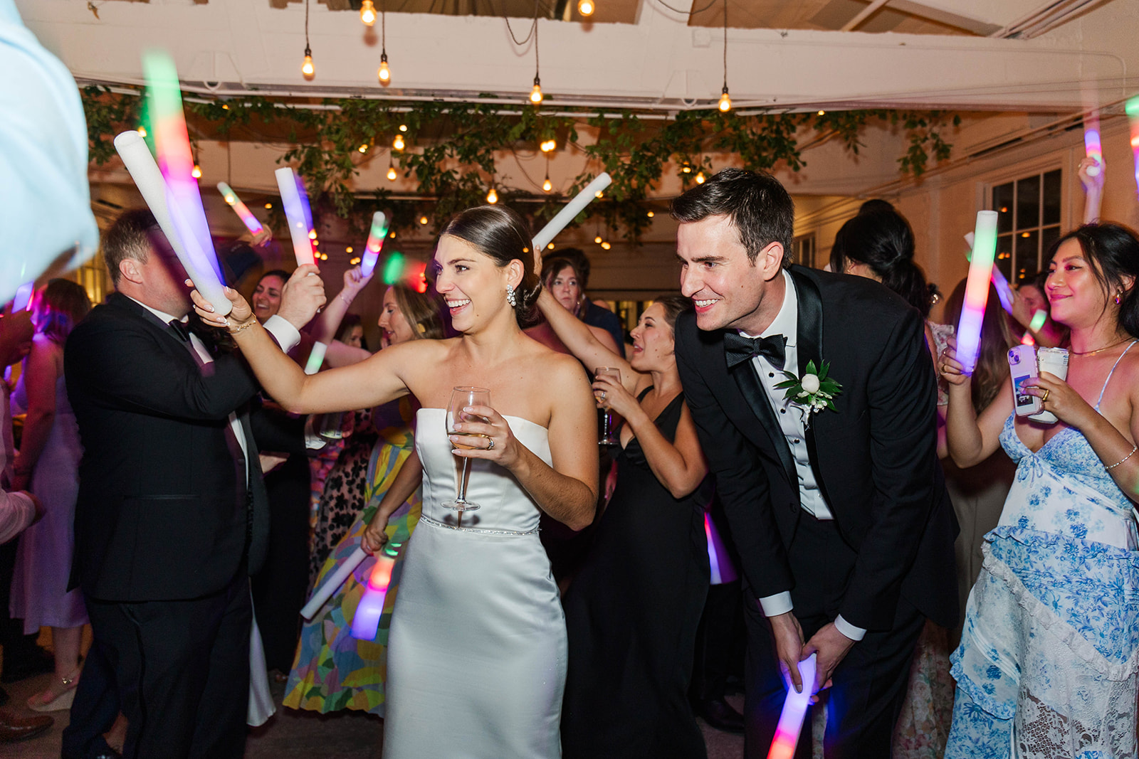 A bride and groom laugh and play with glow rods on the dance floor at their Upstairs Atlanta Wedding
