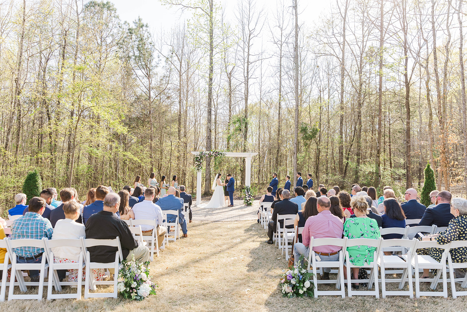 A bride and groom stand under the wedding pergola during their White Fox Cottage ceremony