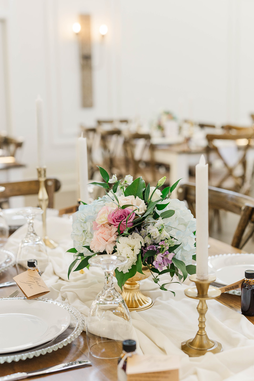 Details of candles and florals on a White Fox Cottage wedding reception table