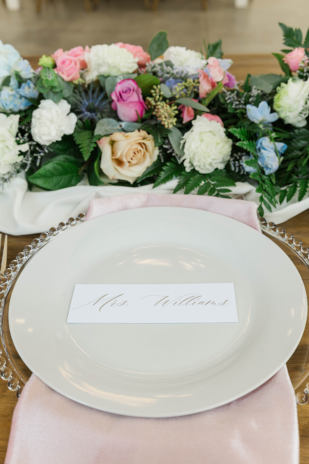 Details of a named place setting with pink napkin