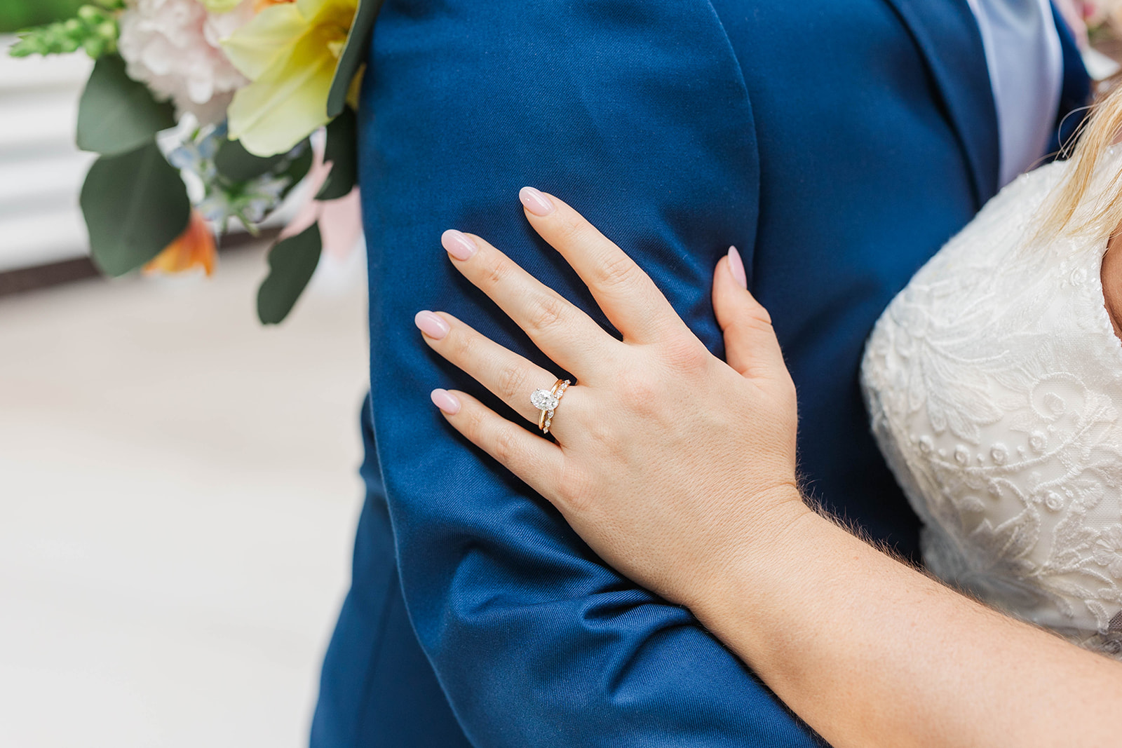 Details of a bride's rings on the groom's blue tux arm at one of the luxury wedding venues in Atlanta