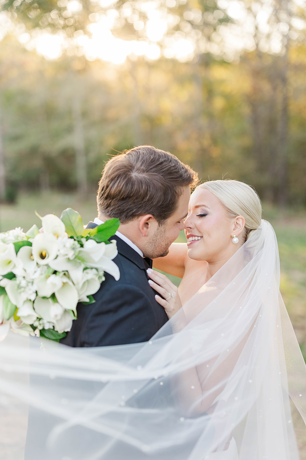 Newlyweds lean in for a kiss at sunset in a lawn at one of the luxury wedding venues in Atlanta