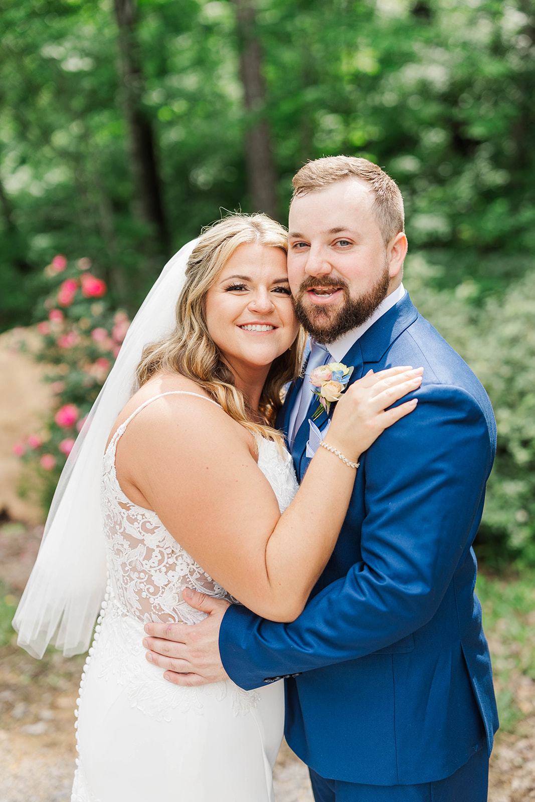 A bride and groom hug and smile in a garden at one of the mansion wedding venues in Atlanta