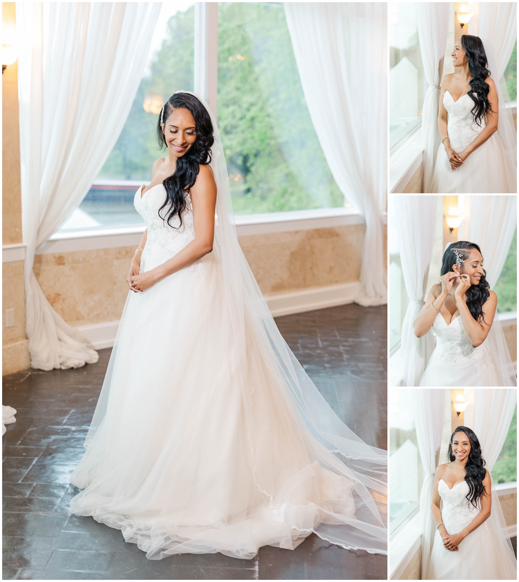A bride smiles down at her gown while standing in a window and putting on earrings