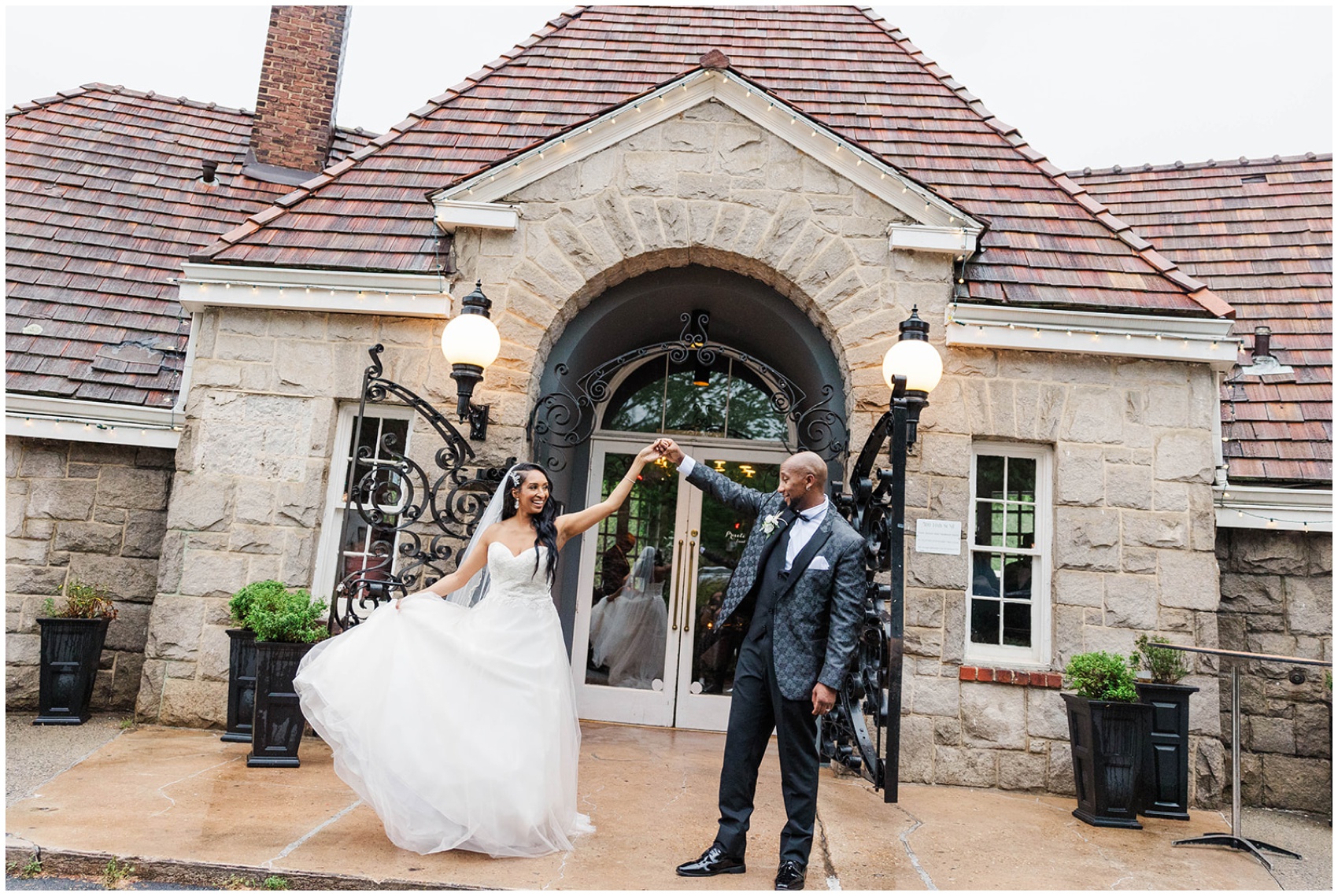 A groom twirls his bride while dancing on the front steps of the Piedmont Room wedding venue