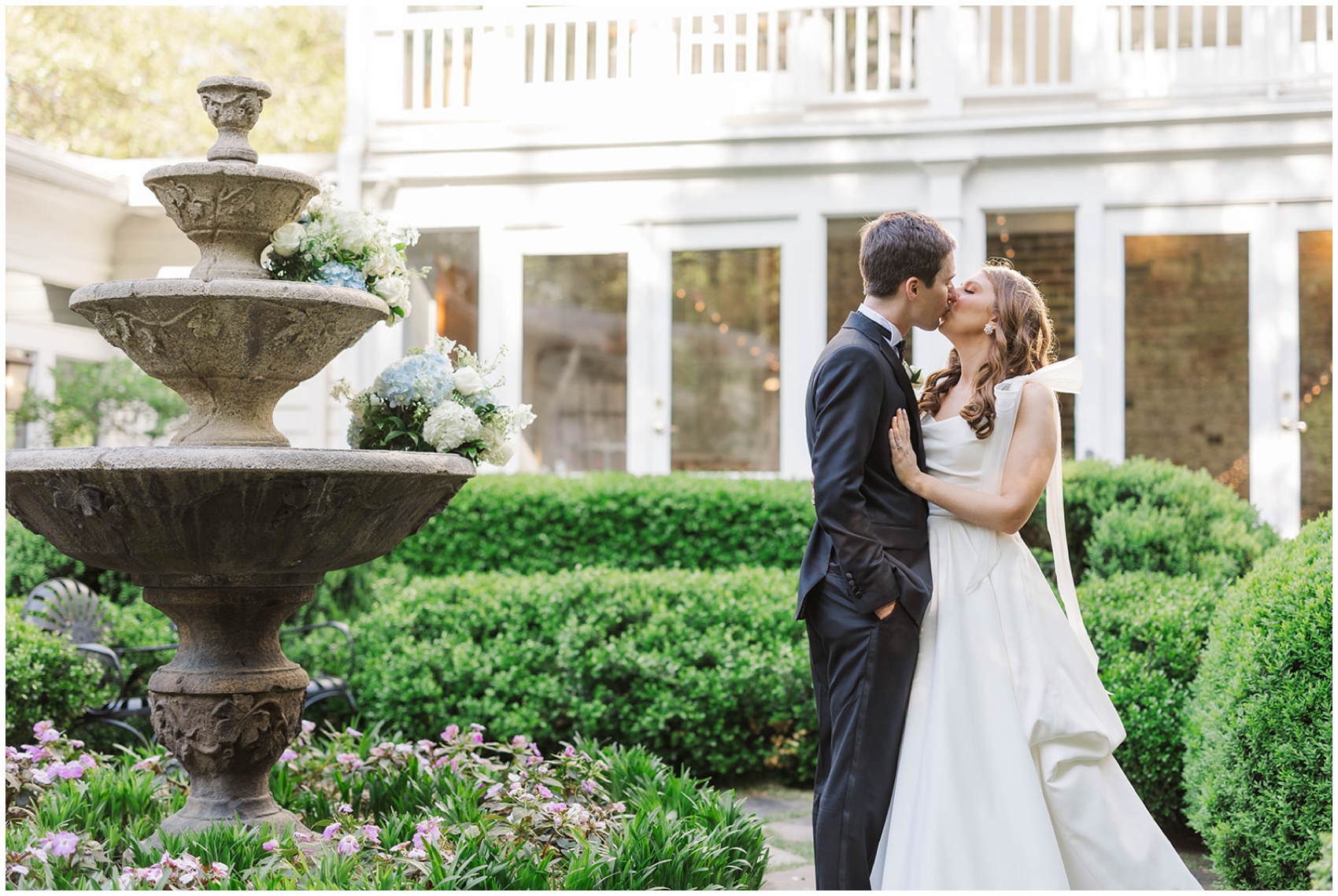 Newlyweds kiss in the lush gardens of the Primrose Cottage wedding venue