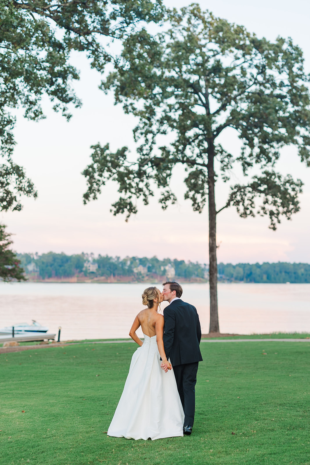 bride and groom kissing during sunset at Great Waters Lake Oconee